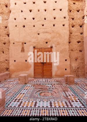 Cortile con alte pareti in terra con pavimenti piastrellati nel Palazzo Badi nella città di Marrakech, alias Marrakech, Marocco, 9 dicembre 2023 Foto Stock