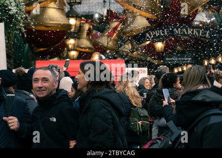 Gente che si gode la falsa caduta di neve a Londra, Covent Garden Foto Stock