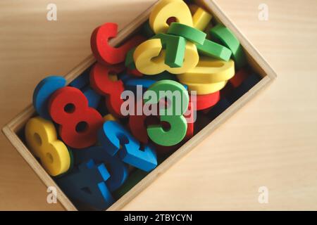 Vista dall'alto della scatola di legno piena di numeri colorati, utilizzata per l'apprendimento dei bambini Foto Stock