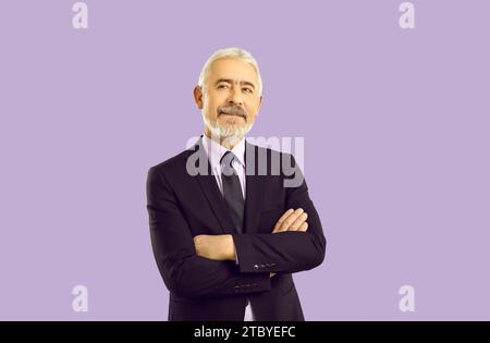 Bellissimo uomo maturo con occhiali e tuta da lavoro con braccia incrociate sorridente e distogliente. Portpait Studio su sfondo viola. Foto Stock