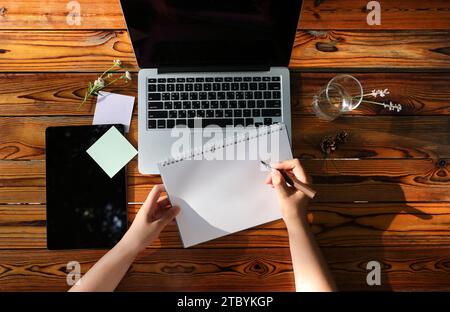 Mani che prendono appunti sul laptop e note vuote Foto Stock