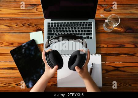 Mano di una donna che tiene una cuffia e inizia una lezione online Foto Stock