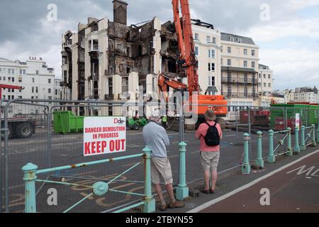 Brighton, East Sussex, Regno Unito, 21 luglio 2023, due persone che guardano la demolizione del Royal Albion Hotel devastata da un grave incendio. Foto Stock