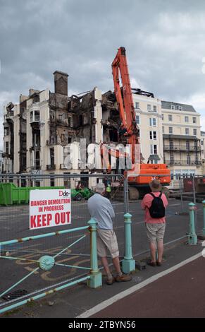 Brighton, East Sussex, Regno Unito, 21 luglio 2023, due persone che guardano la demolizione del Royal Albion Hotel devastata da un grave incendio. Foto Stock