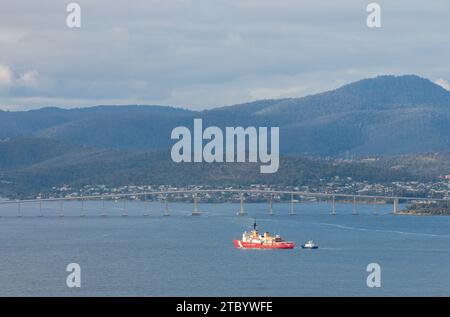 Hobart, Tasmania, Australia - 12 dicembre 2022: Nave della Guardia Costiera DEGLI STATI UNITI che entra nel porto di Hobart con assistenza di imbarcazioni tig Foto Stock