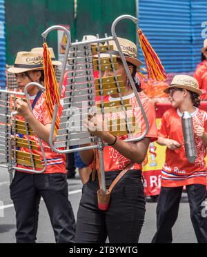 Due giovani che suonano una lira campana verticale e uno che suona un guiro in una parata a San José, in Costa Rica. Foto Stock