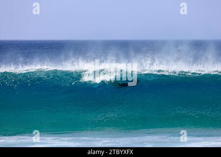 C'è qualcosa nell'acqua! Ombra vista attraverso le onde soffiate da forti venti, El Cotillo, Fuerteventura, Isole Canarie, Spagna. Presa nel novembre 2023 Foto Stock