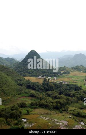 Un piccolo villaggio e campi di riso raccolti nelle montagne del Vietnam del Nord Foto Stock