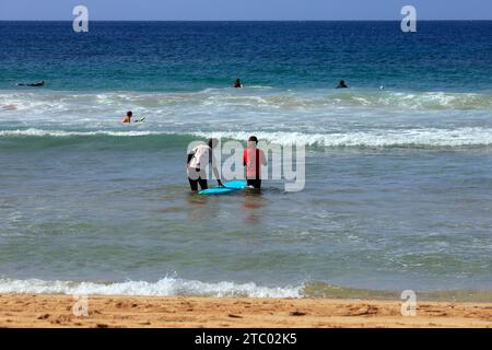 Uomo che prende la prima lezione di surf con istruttore individuale, El Cotillo, Fuerteventura, Isole Canarie, Spagna. Presa nel novembre 2023 Foto Stock