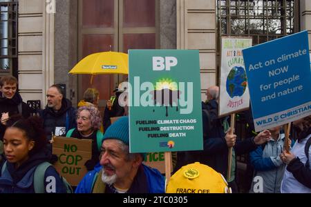 Londra, Regno Unito. 9 dicembre 2023. Un manifestante tiene un cartello anti-BP durante la dimostrazione. Gli attivisti del clima si sono riuniti fuori dalla sede centrale della BP nel centro di Londra per protestare contro le compagnie petrolifere che hanno preso il controllo della COP28 e invocato la giustizia climatica. Credito: SOPA Images Limited/Alamy Live News Foto Stock