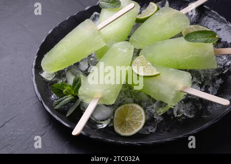 Ghiaccioli di lime e menta fatti in casa impilati su un piatto con ghiaccio Foto Stock