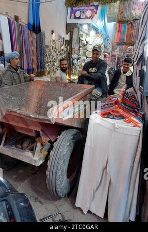 Digger viene guidato lungo le stradine della medina mentre la gente sorride, Marrakech, Marocco, 9 dicembre 2023 Foto Stock