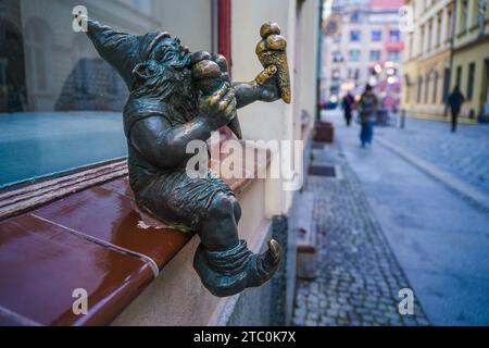 Wrocław, polonia - 8 dicembre 2023: Nano di nome Bartonik seduto su una finestra e mangiato un'icona del gelato Foto Stock