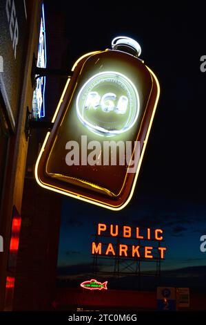 Una bottiglia di liquore si trova sopra una taverna nel centro di Seattle, vicino al mercato di Pike Place, ed è illuminata di notte Foto Stock