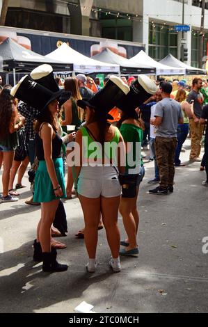 Un gruppo di amici celebra il giorno di San Patrizio indossando una birra verde e bevendo una birra nel centro di Los Angeles Foto Stock