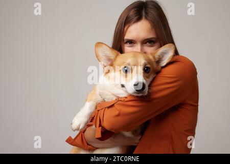ritratto di una ragazza e di un cane corgi su uno sfondo bianco pulito, amore per gli animali Foto Stock