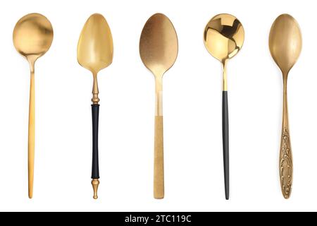 Diversi cucchiai dorati su sfondo bianco Foto Stock