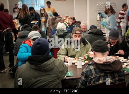 Vancouver, Canada. 9 dicembre 2023. Durante la cena di Natale annuale presso la Union Gospel Mission (UGM) di Vancouver, British Columbia, Canada, il 9 dicembre 2023, si gustano i pasti. Crediti: Liang Sen/Xinhua/Alamy Live News Foto Stock