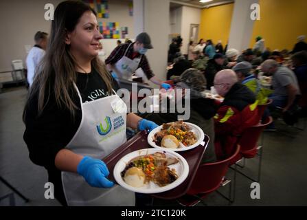 Vancouver, Canada. 9 dicembre 2023. Un volontario serve cibo durante la cena di Natale annuale alla Union Gospel Mission (UGM) a Vancouver, British Columbia, Canada, il 9 dicembre 2023. Crediti: Liang Sen/Xinhua/Alamy Live News Foto Stock