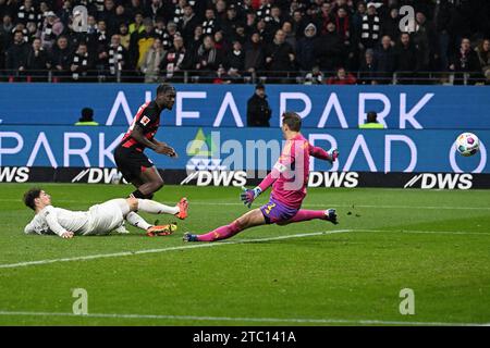 Francoforte, Germania. 9 dicembre 2023. Eric Junior Dina Emimbe (C) dell'Eintracht Frankfurt tira a segno durante la partita di prima divisione della Bundesliga tra l'Eintracht Frankfurt e il Bayern Monaco a Francoforte, Germania, 9 dicembre 2023. Crediti: Ulrich Hufnagel/Xinhua/Alamy Live News Foto Stock