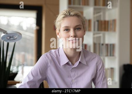 Ritratto di una giovane donna caucasica felice che posa in ufficio Foto Stock