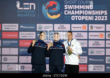 James Guy di Gran Bretagna, argento, Matthew Richards di Gran Bretagna, oro, Danas Rapsys di Lituania, bronzo, mostra le medaglie dopo aver gareggiato nella finale maschile 200m Freestyle durante i Campionati europei di nuoto corto al Complex Olimpic de Natație Otopeni di Otopeni (Romania), 9 dicembre 2023. Foto Stock