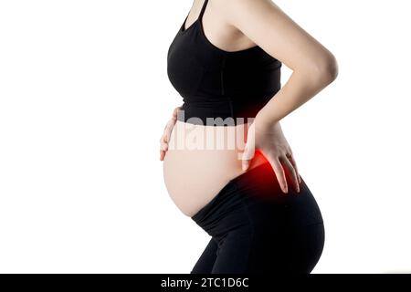 Una donna incinta soffre di mal di schiena (isolata su sfondo bianco) Foto Stock