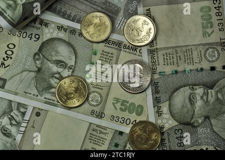 Il dollaro STATUNITENSE è accatastato sotto la valuta indiana di cinquecento rupie insieme alle monete. Foto Stock