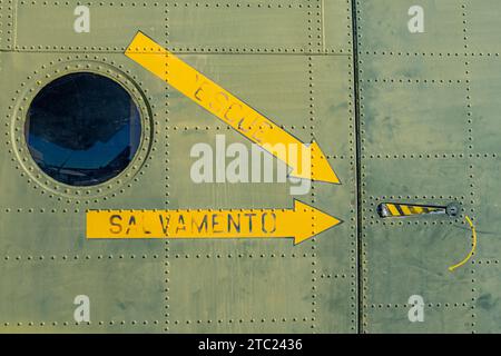 frecce gialle sulla fusoliera dell'aereo che indicano la maniglia della porta di soccorso Foto Stock