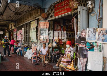 Bangkok, Thailandia. 8 dicembre 2023. All'ingresso di un santuario sulla Charoen Krung Road si trova un salone di bellezza per trattamenti viso e massaggi. Chiamato "mang ming" in tailandese, il threading del viso è un antico metodo di depilazione originario della Cina, dell'India e del mondo arabo. Il metodo utilizza fili di cotone sottili come alternativa alla ceretta o alla pinzatura delle sopracciglia sottili e rimuove i peli superflui del viso. (Foto di Nathalie Jamois/SOPA Images/Sipa USA) credito: SIPA USA/Alamy Live News Foto Stock