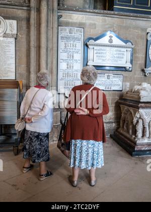 SIGNORE CHE CERCANO I NOMI SU UNA TARGA COMMEMORATIVA NELLA CATTEDRALE DI CANTERBURY - VISITATORI DEL LUOGO STORICO - STORIA INGLESE - ANZIANI © F.BEAUMONT Foto Stock