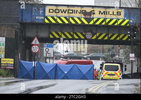 Highgate Road, Birmingham 10 dicembre 2023 - Una donna di vent'anni è morta dopo che la BMW che guidava era in collisione con un taxi nella zona di Sparkbrook a Birmingham poco prima delle 2 di domenica mattina. La polizia e i vigili del fuoco erano ancora sulla scena a mezzogiorno per indagare. Un grande schermo blu copriva l'incidente su un lato sotto un ponte ferroviario e due veicoli antincendio del supporto tecnico bloccavano l'altro lato. Credito: Stop Press Media/Alamy Live News Foto Stock