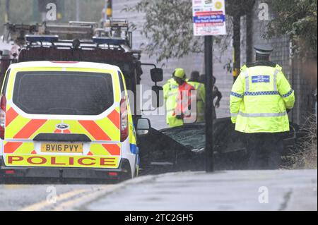 Highgate Road, Birmingham 10 dicembre 2023 - Una donna di vent'anni è morta dopo che la BMW che guidava era in collisione con un taxi nella zona di Sparkbrook a Birmingham poco prima delle 2 di domenica mattina. La polizia e i vigili del fuoco erano ancora sulla scena a mezzogiorno per indagare. Un grande schermo blu copriva l'incidente su un lato sotto un ponte ferroviario e due veicoli antincendio del supporto tecnico bloccavano l'altro lato. Credito: Stop Press Media/Alamy Live News Foto Stock