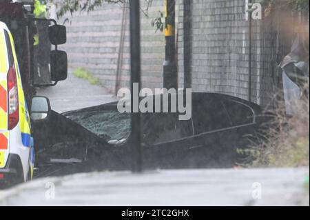 Highgate Road, Birmingham 10 dicembre 2023 - Una donna di vent'anni è morta dopo che la BMW che guidava era in collisione con un taxi nella zona di Sparkbrook a Birmingham poco prima delle 2 di domenica mattina. La polizia e i vigili del fuoco erano ancora sulla scena a mezzogiorno per indagare. Un grande schermo blu copriva l'incidente su un lato sotto un ponte ferroviario e due veicoli antincendio del supporto tecnico bloccavano l'altro lato. Credito: Stop Press Media/Alamy Live News Foto Stock