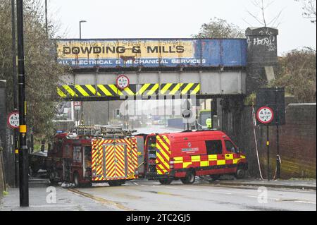 Highgate Road, Birmingham 10 dicembre 2023 - Una donna di vent'anni è morta dopo che la BMW che guidava era in collisione con un taxi nella zona di Sparkbrook a Birmingham poco prima delle 2 di domenica mattina. La polizia e i vigili del fuoco erano ancora sulla scena a mezzogiorno per indagare. Un grande schermo blu copriva l'incidente su un lato sotto un ponte ferroviario e due veicoli antincendio del supporto tecnico bloccavano l'altro lato. Credito: Stop Press Media/Alamy Live News Foto Stock