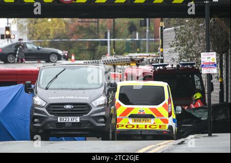 Highgate Road, Birmingham 10 dicembre 2023 - Una donna di vent'anni è morta dopo che la BMW che guidava era in collisione con un taxi nella zona di Sparkbrook a Birmingham poco prima delle 2 di domenica mattina. La polizia e i vigili del fuoco erano ancora sulla scena a mezzogiorno per indagare. Un grande schermo blu copriva l'incidente su un lato sotto un ponte ferroviario e due veicoli antincendio del supporto tecnico bloccavano l'altro lato. Credito: Stop Press Media/Alamy Live News Foto Stock