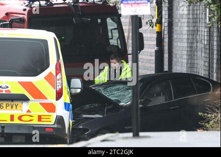 Highgate Road, Birmingham 10 dicembre 2023 - Una donna di vent'anni è morta dopo che la BMW che guidava era in collisione con un taxi nella zona di Sparkbrook a Birmingham poco prima delle 2 di domenica mattina. La polizia e i vigili del fuoco erano ancora sulla scena a mezzogiorno per indagare. Un grande schermo blu copriva l'incidente su un lato sotto un ponte ferroviario e due veicoli antincendio del supporto tecnico bloccavano l'altro lato. Credito: Stop Press Media/Alamy Live News Foto Stock