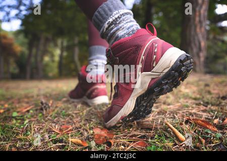 Primo piano di piedi che camminano fuori dal sentiero forestale. Girl Trail Running. Vista laterale Foto Stock