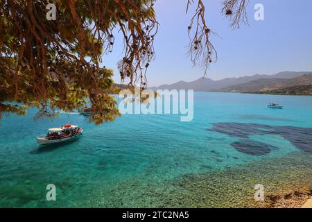 Piccola barca di turisti che si avvicinano all'isola di Spinalonga, Creta. Grecia, Europa. Foto Stock