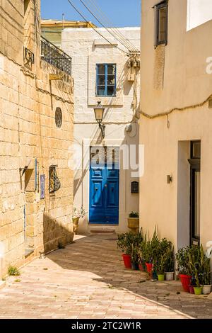 La tipica porta blu nei villaggi maltesi in un vicolo stretto Foto Stock