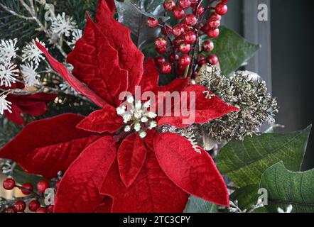 Poinsettia artificiale e bacche su un albero di Natale a Ginza, Chūō Tokyo, Giappone. Foto Stock