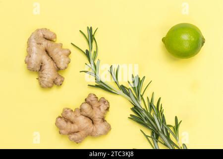 Zenzero, rametto di rosmarino e lime. Rimedio alternativo per il raffreddore e l'influenza. Assistenza sanitaria. Sfondo giallo. Spianatura piatta Foto Stock