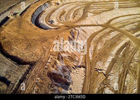 Vista aerea dei modelli di strade su una cava di sabbia. Estrazione di sabbia da costruzione in una grande cava Foto Stock