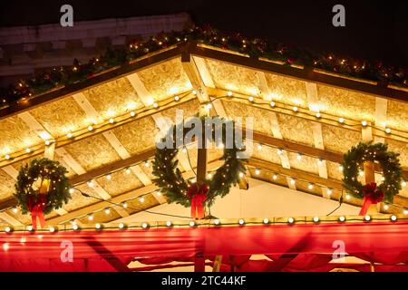 Jute palla con pizzo sull'albero di Natale su uno sfondo di legno. Un arco di burlap. Decorazioni rustiche di Natale. Decorazioni per il nuovo anno in un bosco Foto Stock