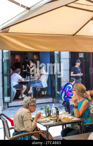 Persone sedute all'aperto al sole a mangiare e bere nella città ispagnola di Salamanca in Spagna Foto Stock