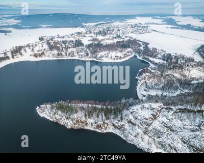 Bacino idrico sec con diga in cemento e colline innevate invernali delle Iron Mountains. Cechia. Vista aerea dal drone. Foto Stock