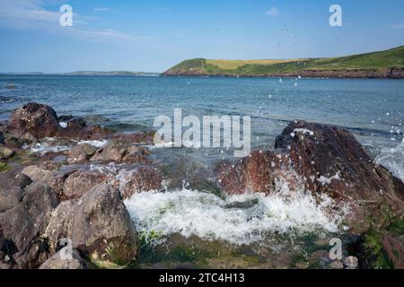 Onde marine che si infrangono contro le rocce di Manorbier Beach pembrokeshire, Galles del Sud Foto Stock