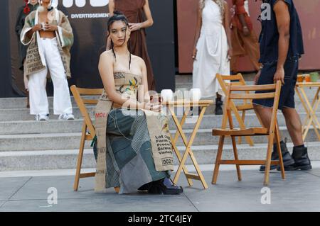 Una modella asiatica siede su una sedia alla sfilata di moda Par Danika che si tiene a Montreal, Quebec, Canada Foto Stock