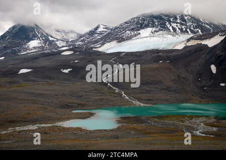 Un lago ghiacciato azzurro vicino al rifugio Nallo, Lapponia, Svezia Foto Stock