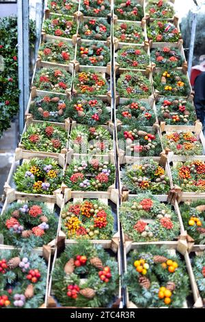 Numerose ghirlande natalizie in scatole di legno in vendita al mercato dei fiori Foto Stock